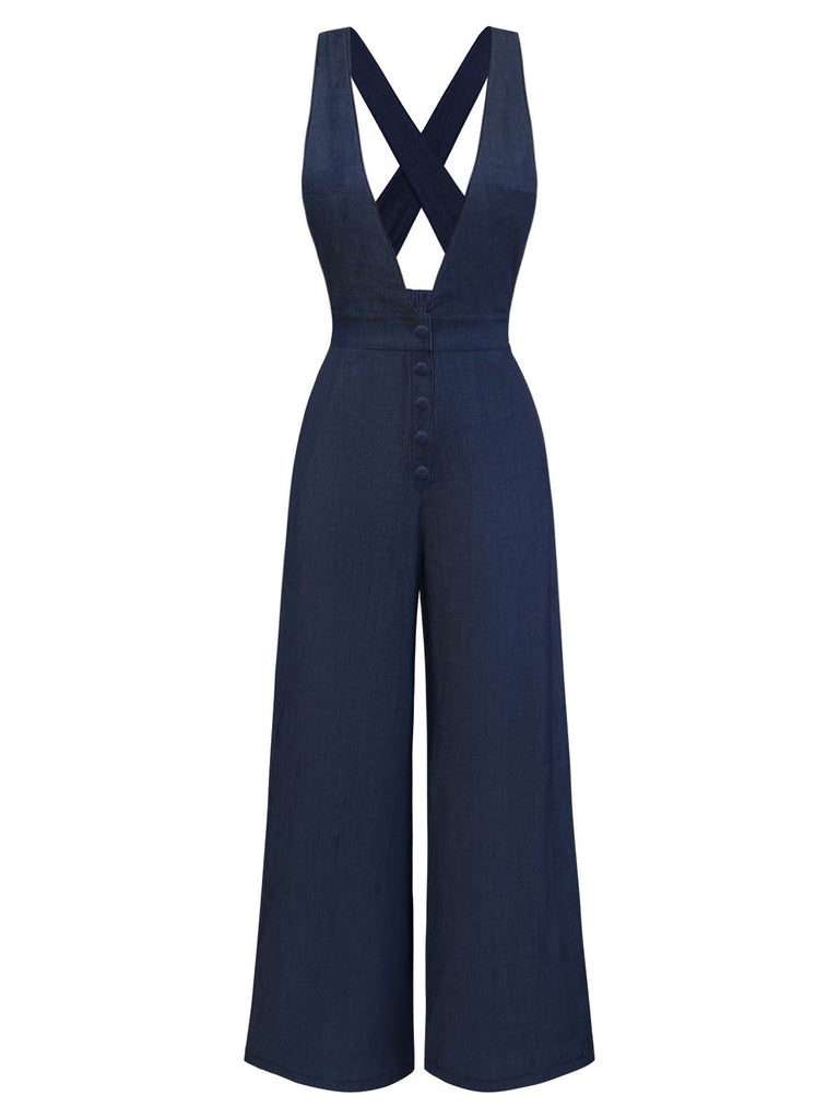 Standing rear view of the navy jumpsuit showcasing the cross-back straps and flowing trouser legs.