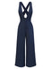 Standing rear view of the navy jumpsuit showcasing the cross-back straps and flowing trouser legs.