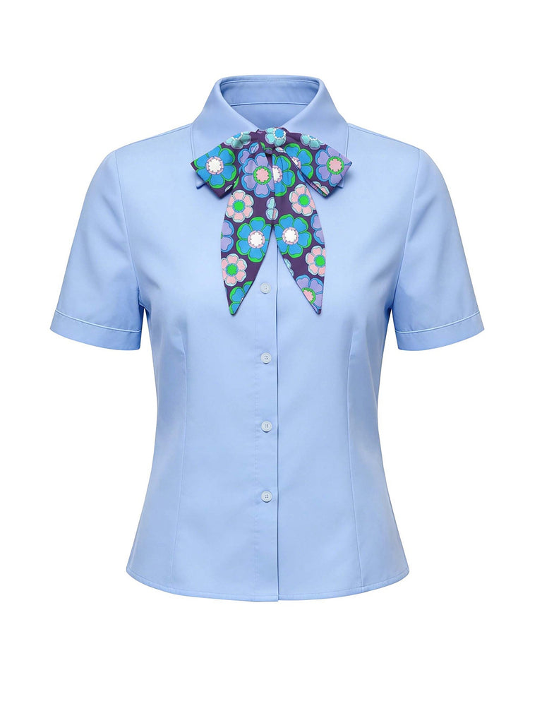 Light blue shirt with a decorative floral bow on a white background