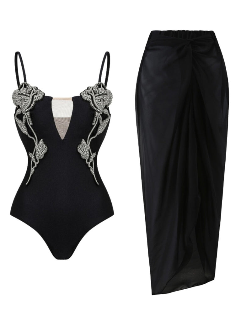 Black swimsuit with decorative straps and a black skirt on a white background