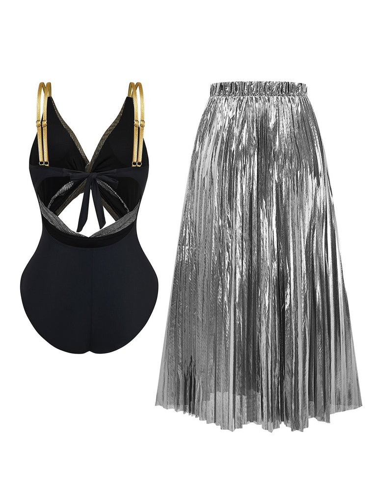 Black swimsuit with gold accents and silver pleated skirt on a white background