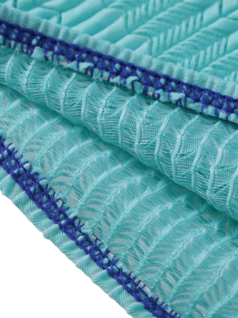 Close-up of teal fabric with blue stitching on a white background