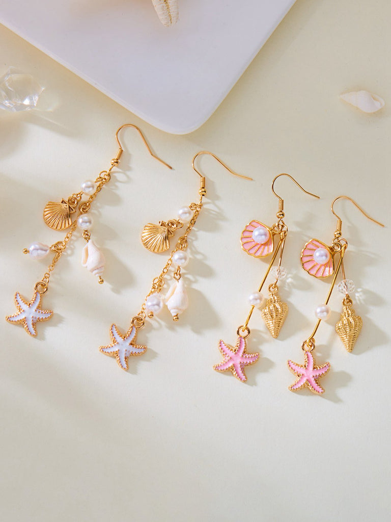 Set of gold earrings with starfish and shell designs on a light background