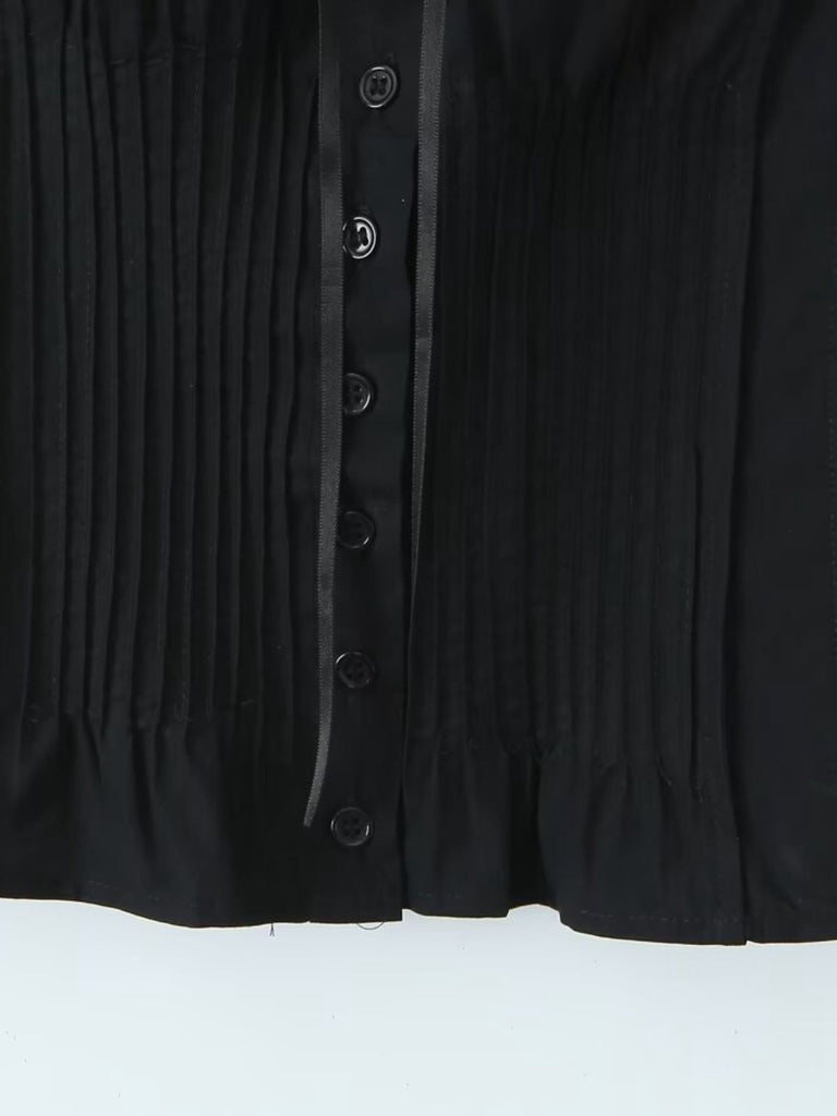 Close-up of a black buttoned garment on a white background