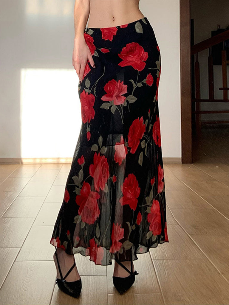 Person wearing a black floral skirt with red flowers indoors.