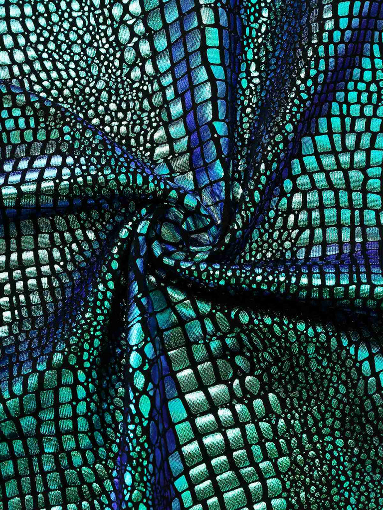 Close-up of a textured fabric with a pattern resembling scales in blue and green.