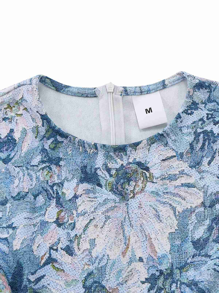 Close-up of a blue floral dress with a brand tag on a white background