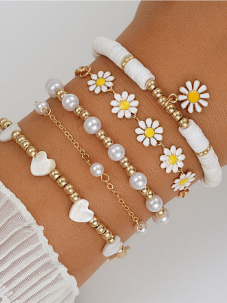 Bohemian stackable bracelet set with delicate daisy, pearl, and heart beads, adding a whimsical touch to summer festival outfits or casual everyday wear.