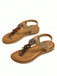 Pair of tan sandals with decorative elements on a white background