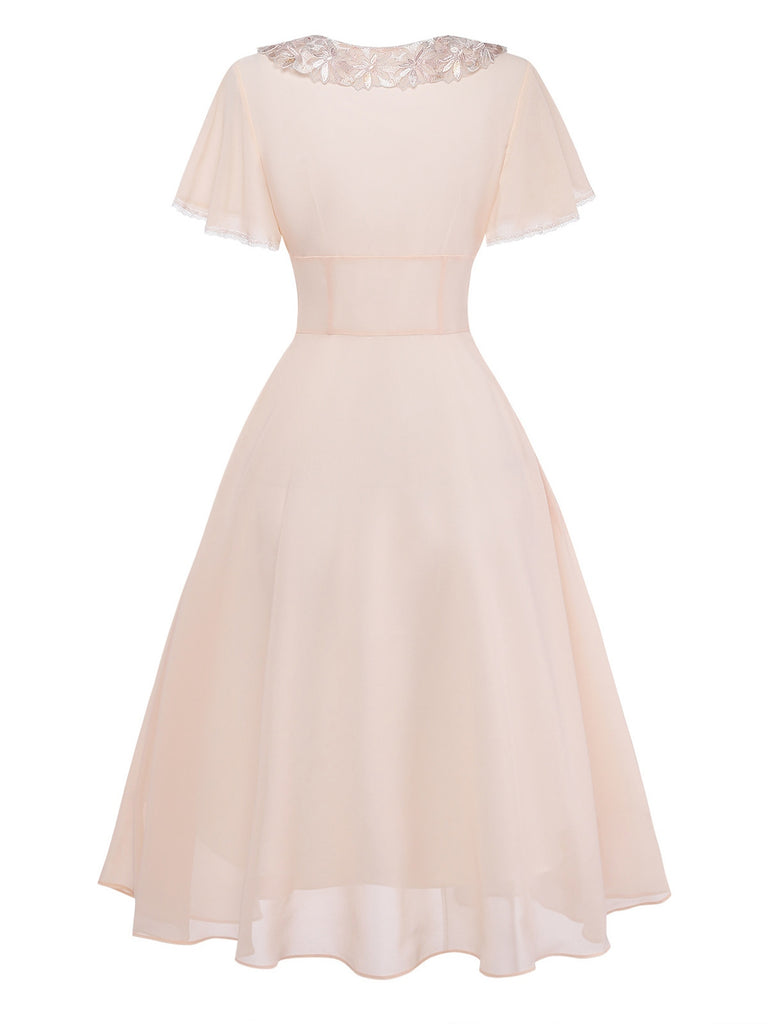 Blush pink dress with lace neckline on a white background