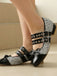 Black and silver glittery shoes with buckles on a neutral background