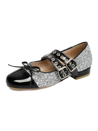Black and silver glittery flat shoe with buckles on a white background
