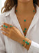 Woman wearing Green necklaces, rings, and bracelets with green gemstones on a white shirt.