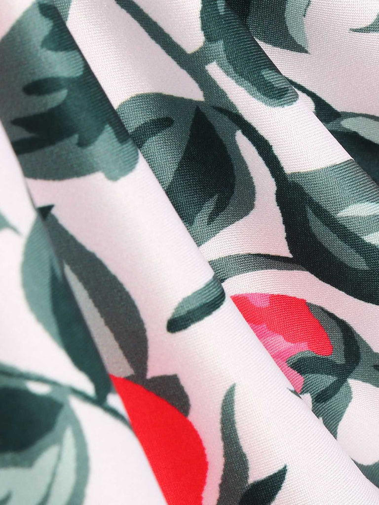Close-up of fabric with green leaf pattern and red accents on a white background
