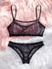 Black lace lingerie set on a pink and white fluffy surface