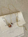 She adds this Red Pomegranate Pendant Necklace and suddenly it's vintage perfection