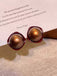 She adds this Vintage Brown Dome Glossy Earrings and suddenly it's 1950s perfection