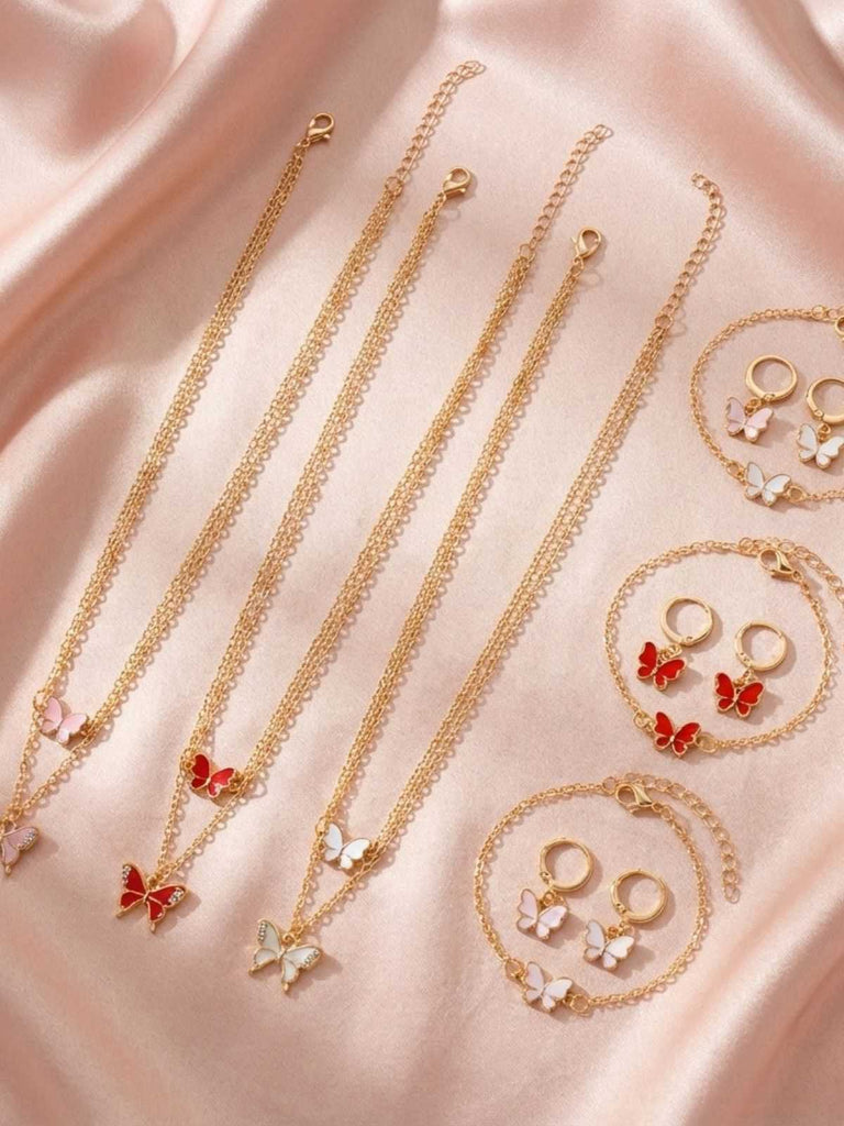 Gold jewelry set with necklaces and earrings on a pink satin background