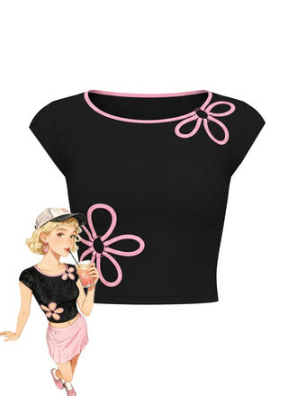 A fitted black short-sleeve crop top featuring pink piped trim and two large pink floral outline embroideries, shown with a retro-style illustration.