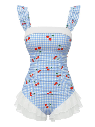 Vintage blue one-piece swimsuit with cherry plaid pattern and romantic ruffled mesh overlay, perfect for 1950s pinup-inspired beach styling