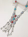 A long silver bohemian statement necklace featuring turquoise, coral, and white stones with a cascading chain fringe.
