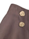 Close-up of the waistband on the taupe skirt highlighting two textured decorative gold buttons and subtle side pleating.