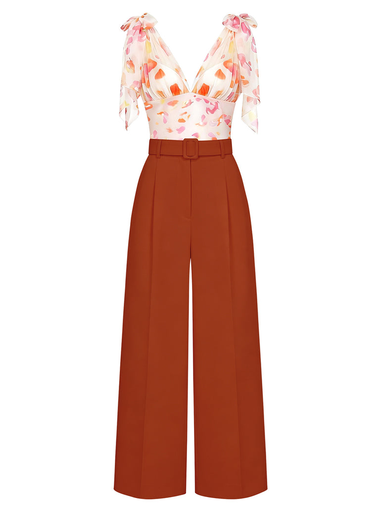 A sophisticated two-piece set featuring a white V-neck bodysuit with a vibrant orange floral print and bow-tie shoulders, paired with high-waisted rust-colored wide-leg trousers.