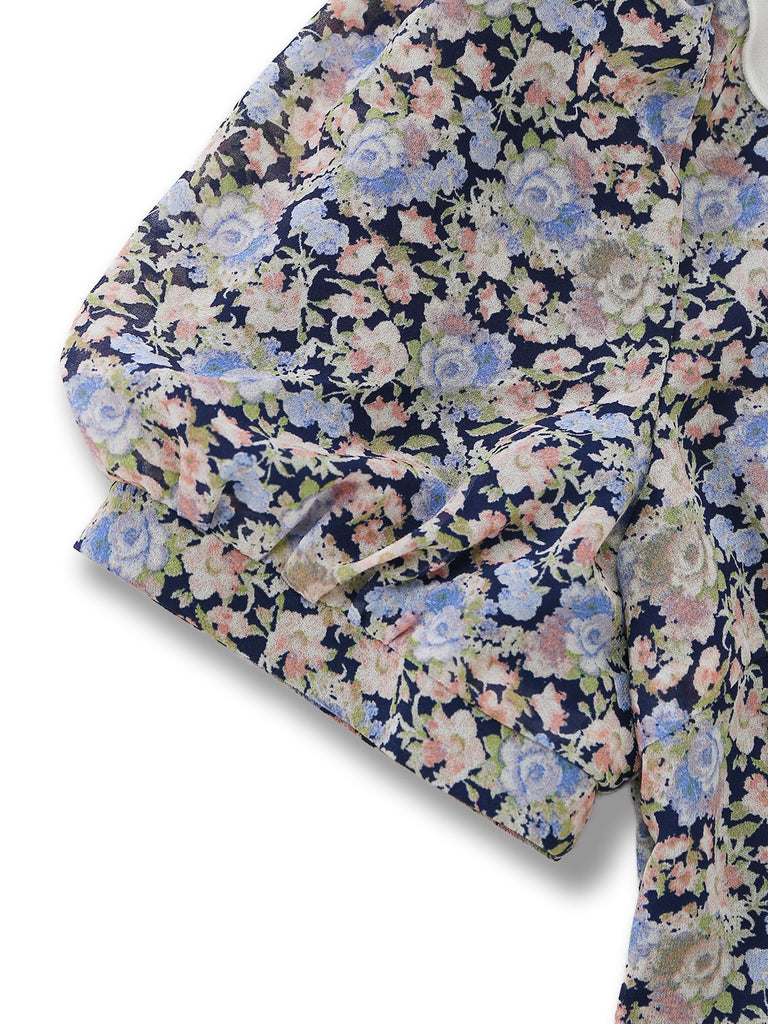 Close-up of the short puff sleeve showing the elasticated cuff and the multi-colored botanical print.