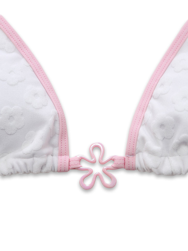 Detailed shot of the white triangle bikini top featuring an embossed floral texture and a pink flower-shaped center charm.