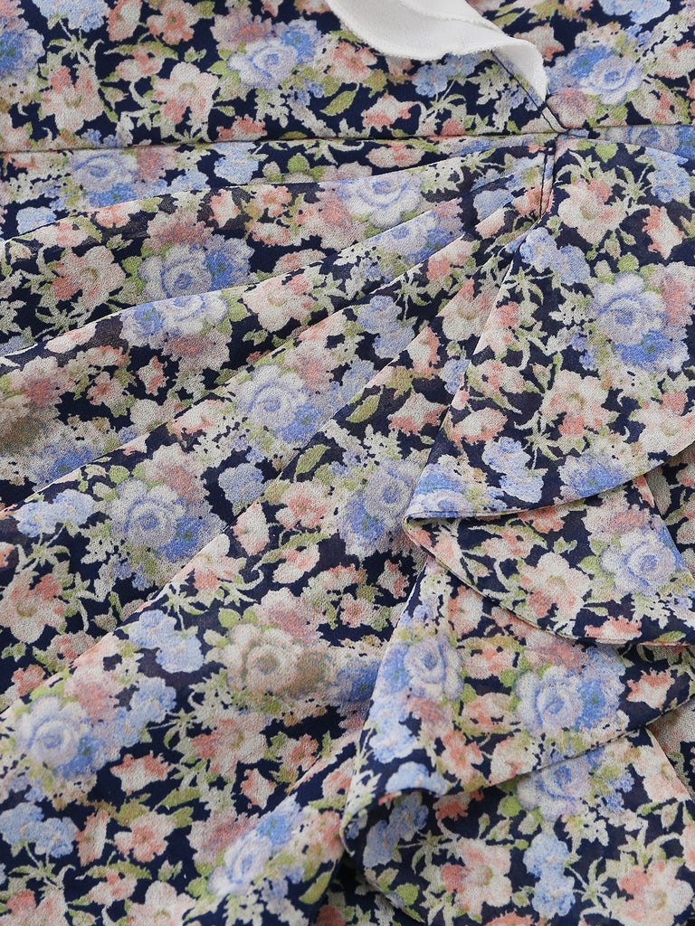 Detail shot of the gathered fabric on the skirt, highlighting the pink, blue, and cream flower motifs.