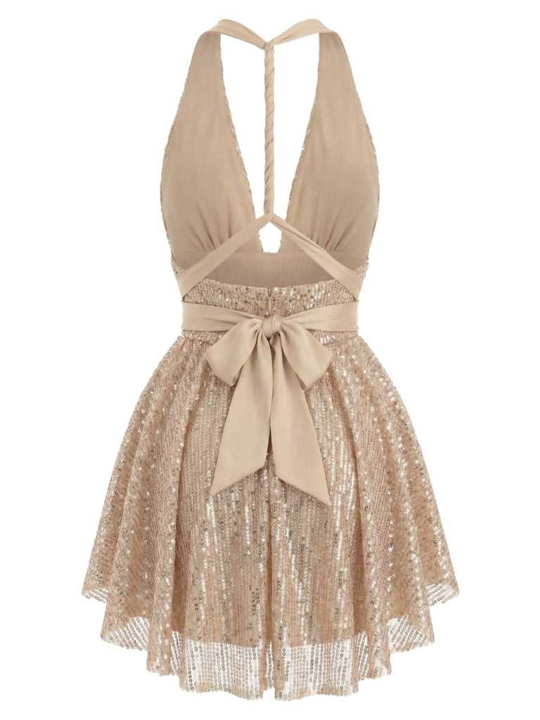 Back view of the gold sequin dress showing the halter-style straps and the bow tied at the back of the waist.