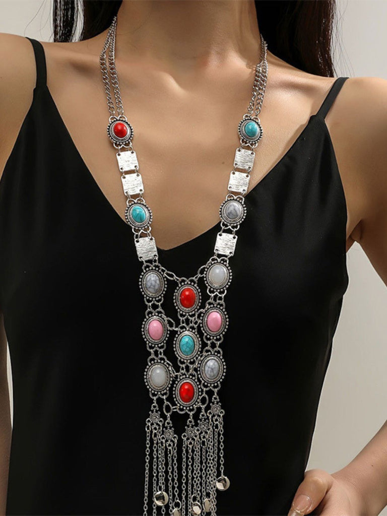 A model wearing the long silver statement necklace over a black top, showcasing the length and drape of the jewelry.