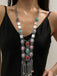 A model wearing the long silver statement necklace over a black top, showcasing the length and drape of the jewelry.