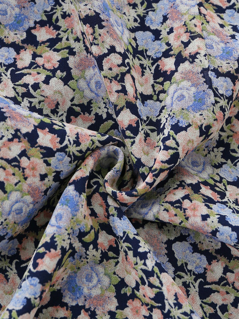 Macro view of the fabric texture and the intricate vintage-style floral pattern on a navy blue background.
