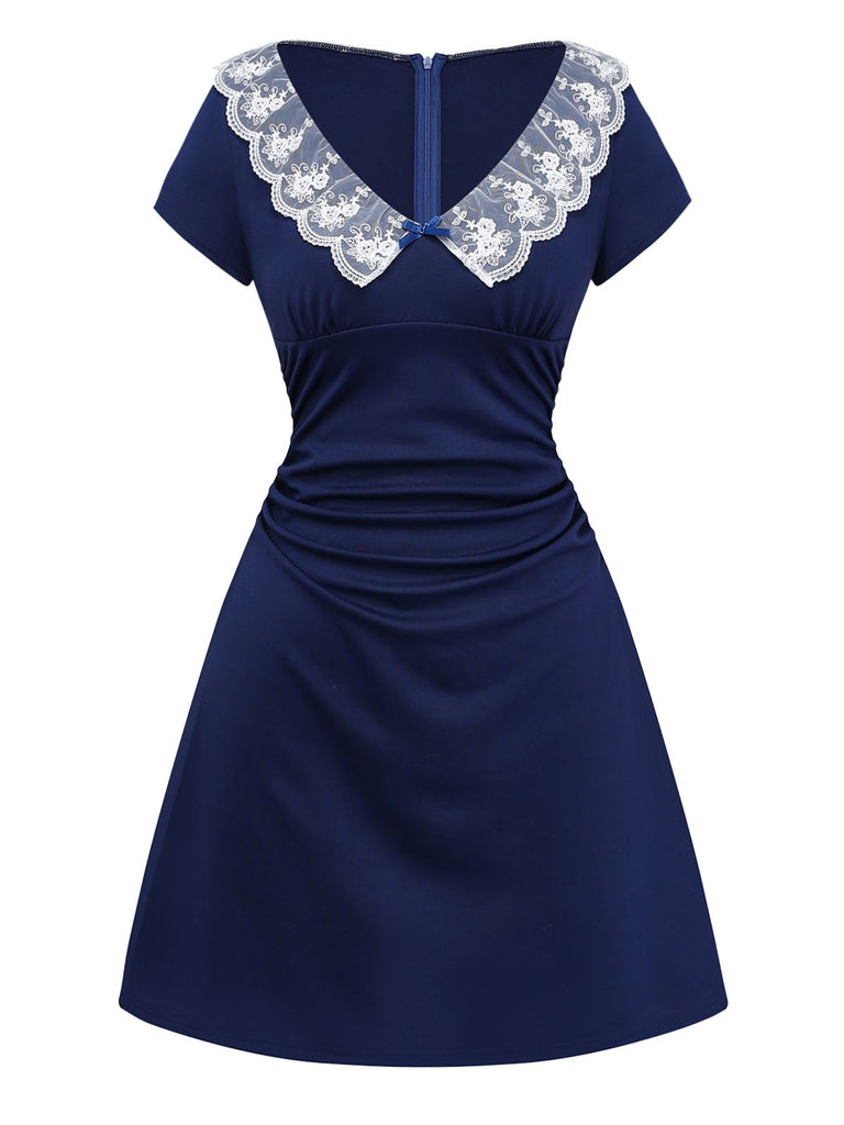 A three-quarter view of the navy blue short-sleeve vintage flare dress showing the flattering ruched waistline.