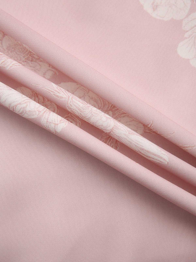 A close-up of the folded pink fabric showcasing its smooth texture and floral design.