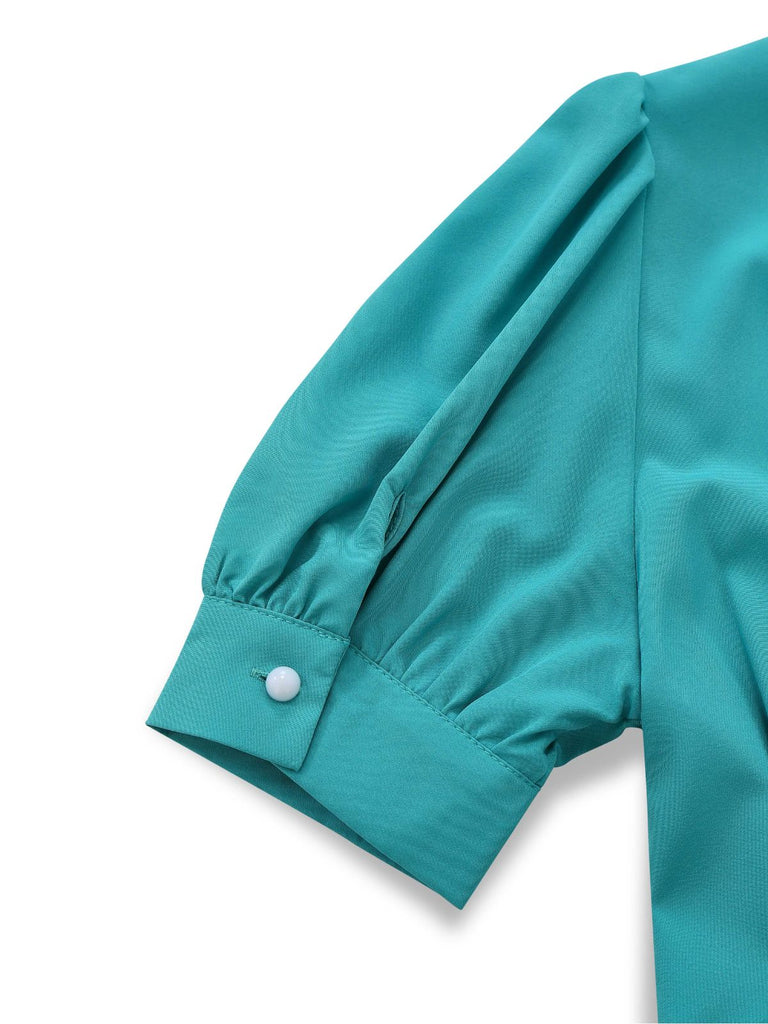 Detailed view of the gathered puff sleeve featuring a structured cuff and a single pearl button closure.