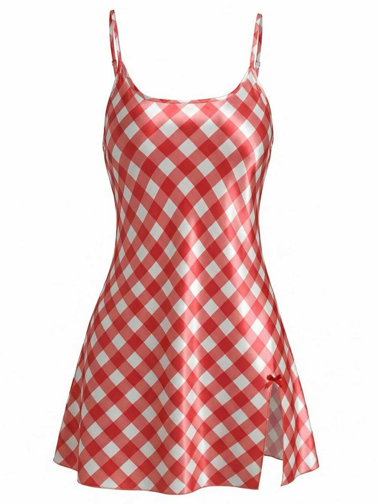 A short, red and white gingham checkered slip dress made of shimmering satin fabric, featuring thin spaghetti straps and a small side slit.