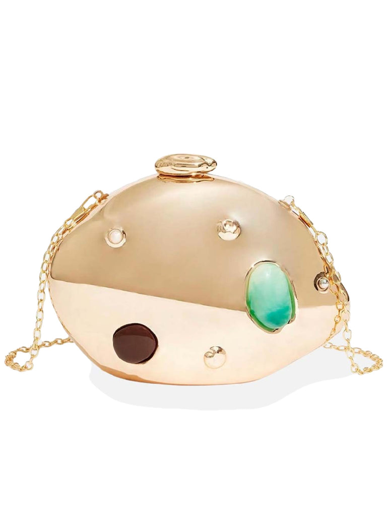 A metallic gold hard-shell clutch with an irregular, organic shape, decorated with various inset stones in green and dark brown.