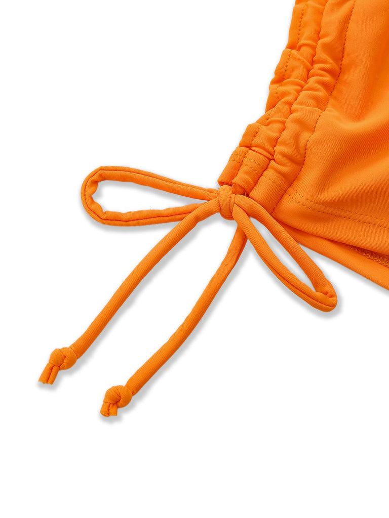 Detailed shot of the adjustable side drawstring ties on the high-waisted orange floral swim bottoms.