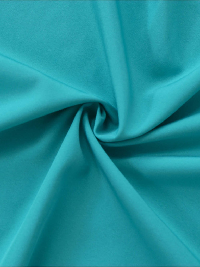 A swirled close-up of the teal fabric showing a fine crepe-like texture and rich color saturation.