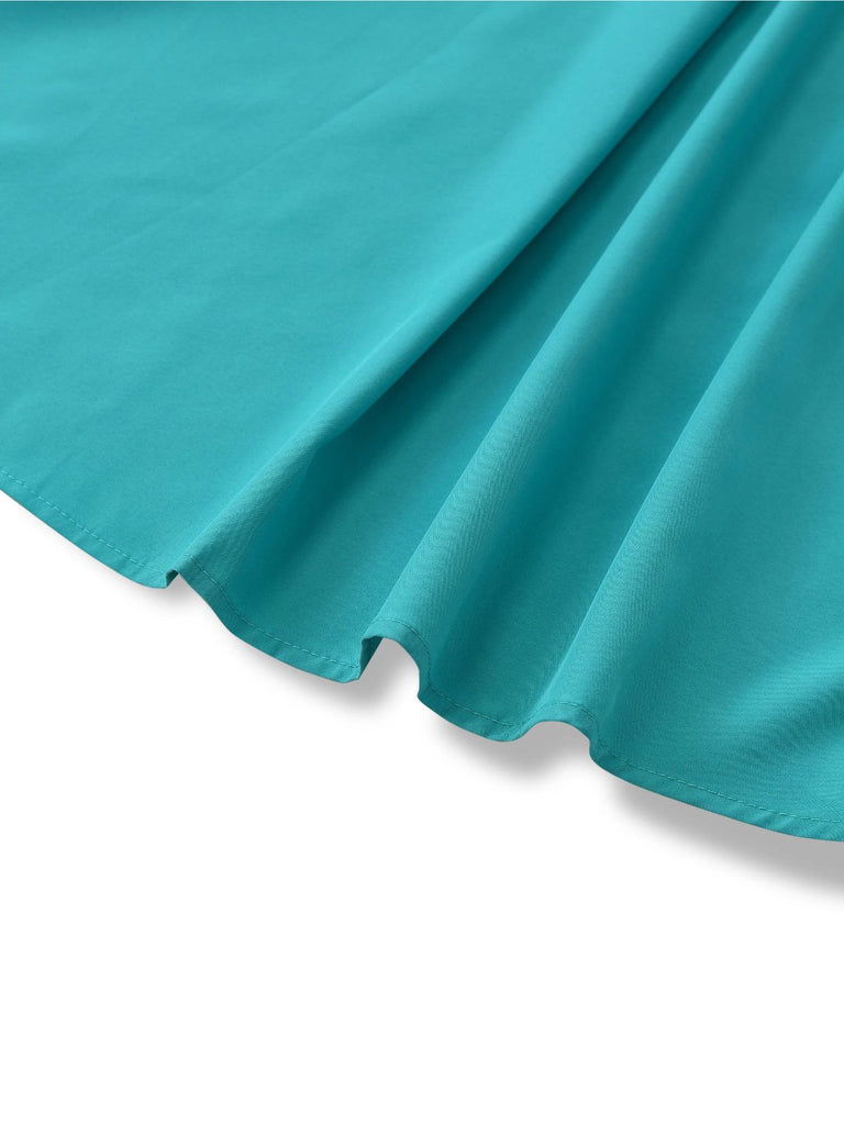 A shot of the flared dress hemline highlighting the lightweight drape of the teal material.
