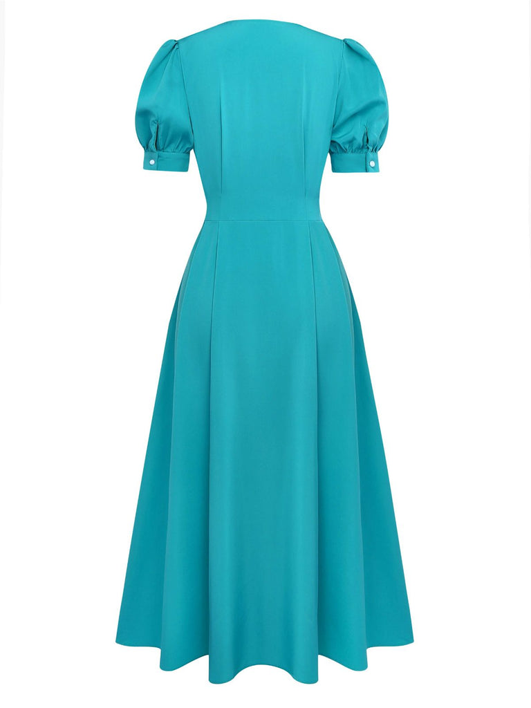 Rear view of the teal puff-sleeve dress showcasing the fitted waist and the smooth, flowing skirt silhouette.