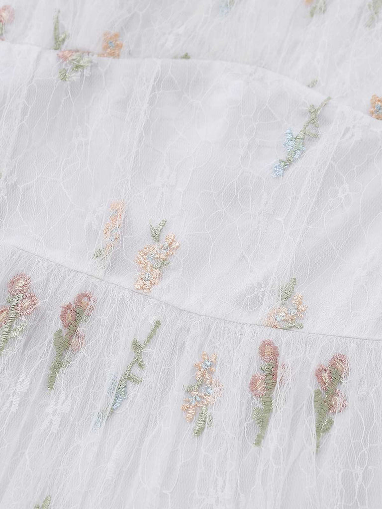 Detailed shot of the ruffled tiers on the skirt, showcasing the delicate floral stitching.
