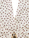 Close-up of a polka dot fabric with a gold ring on a white background