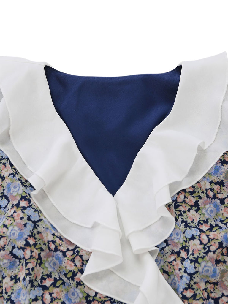 Detailed close-up of the white pleated ruffle collar and the deep V-neckline on the navy blue fabric.